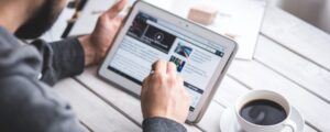 cropped-news-live-man-using-the-digital-touching-tablet-screen-with-coffee-cup.jpg cropped news live man using the digital touching tablet screen with coffee cup